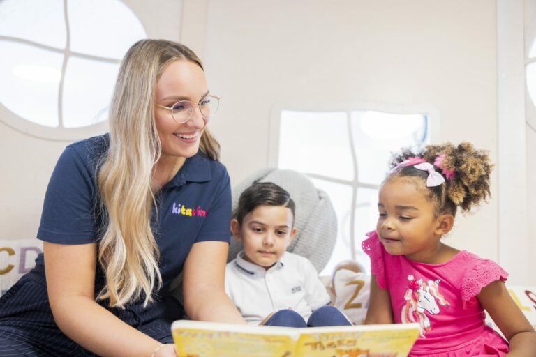 Kitarino Erzieherin liest mit den Kindern ein Buch