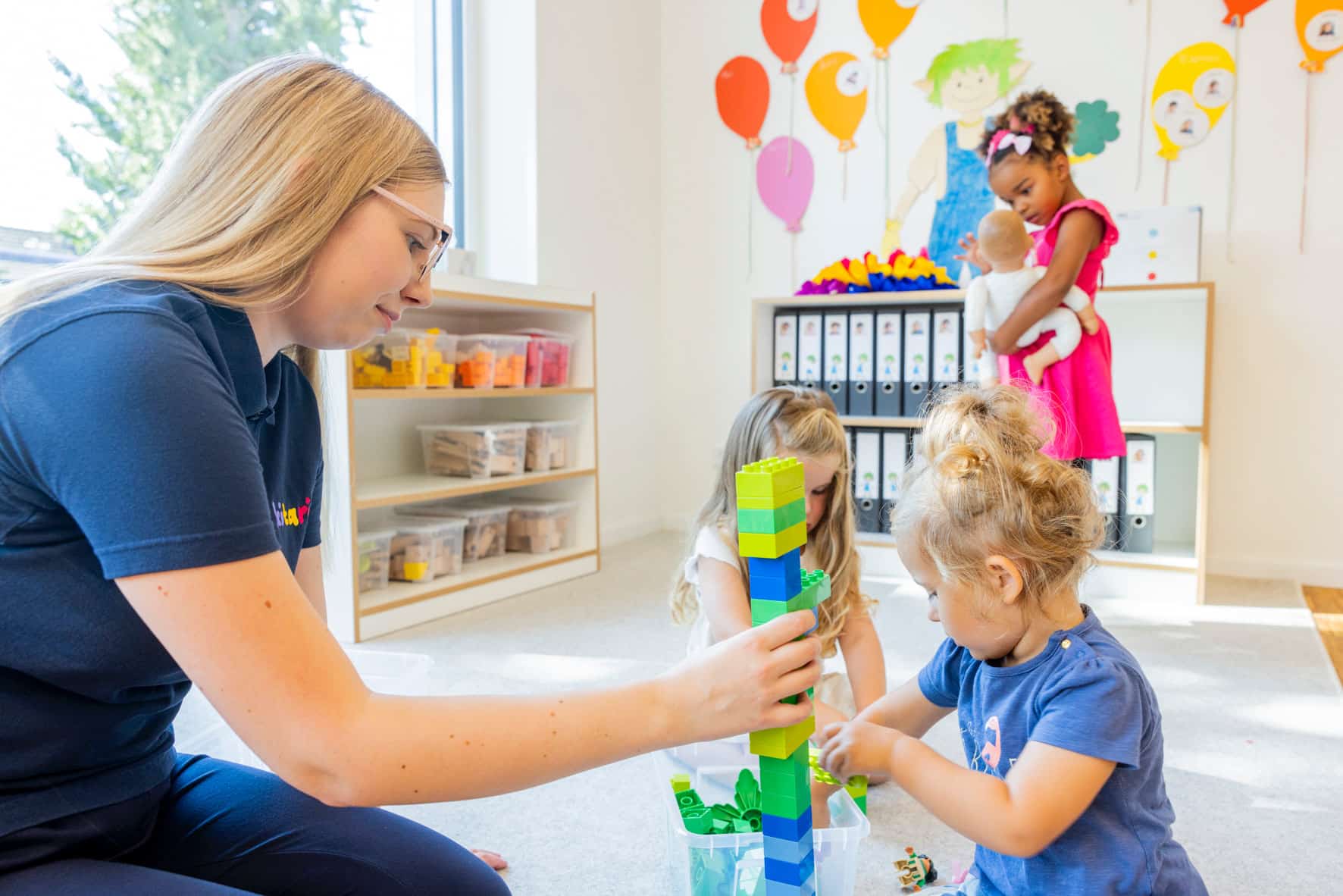 Kind baut einen hohen Turm aus Duplosteinen